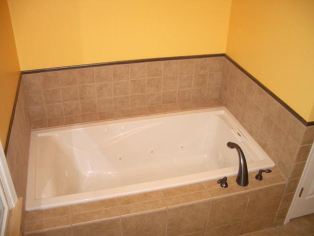 Tile is done around the tub, hardware installed